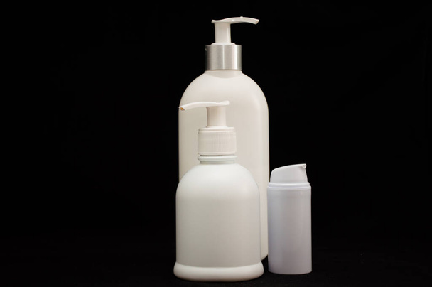 λευκό πλαστικό καλλυντικά μπουκάλι σε μαύρο φόντο - Φωτογραφία, εικόνα