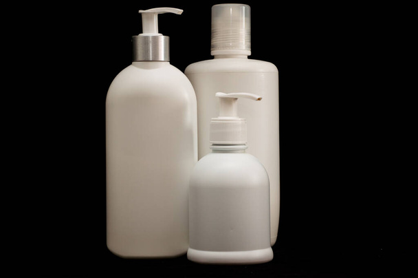 white plastic cosmetic bottle on black background - Zdjęcie, obraz