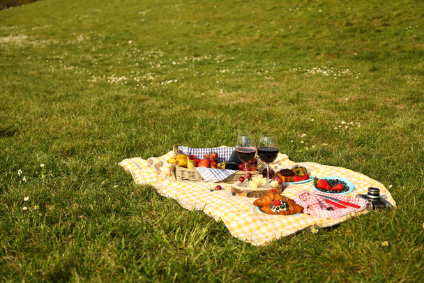 piknik v létě s produkty, sendvič, salát, ovoce, nápoj a klobouk na zelené trávě textury pozadí horní pohled mockup - Fotografie, Obrázek