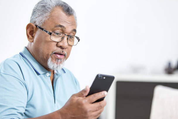 Senior man looking at his phone - Photo, image