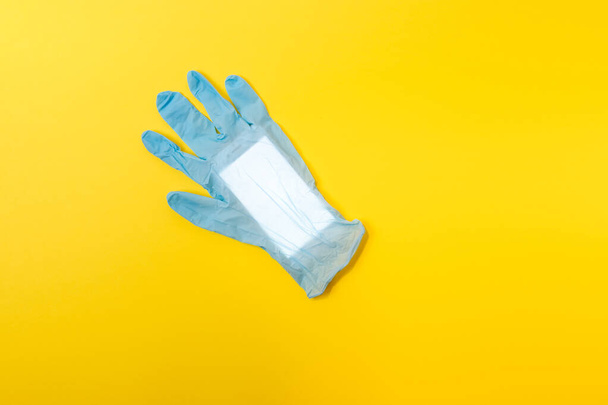 Blue latex medical glove with mobile phone inside. Minimal Coronavirus outbreak. Pandemic concept. - Foto, Imagem