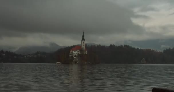 Kościół Timelapse na wyspie w środku jeziora Bled. Chmurna pogoda w górach. Jezioro Bled, Słowenia. 4K - Materiał filmowy, wideo