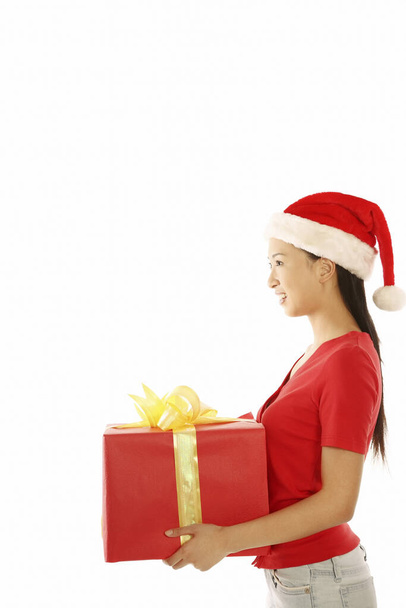 Young woman with christmas hat holding a box of present - 写真・画像