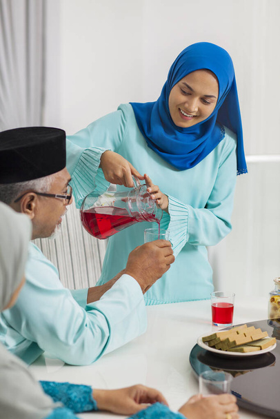 Muslim woman serving beverage to her parent - Foto, Imagen