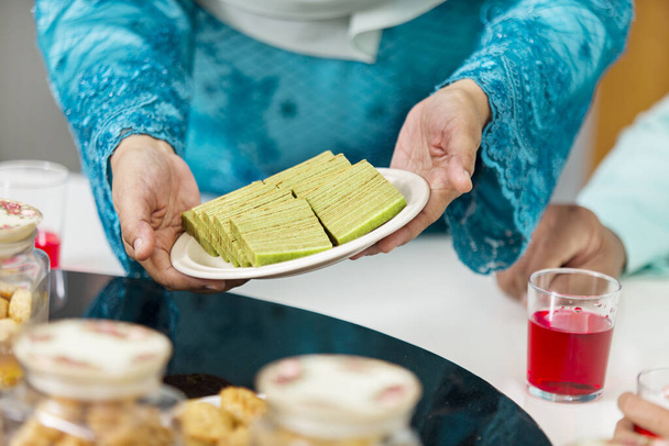 Muslim woman serving food during Eid al-Fitr - Foto, Imagen