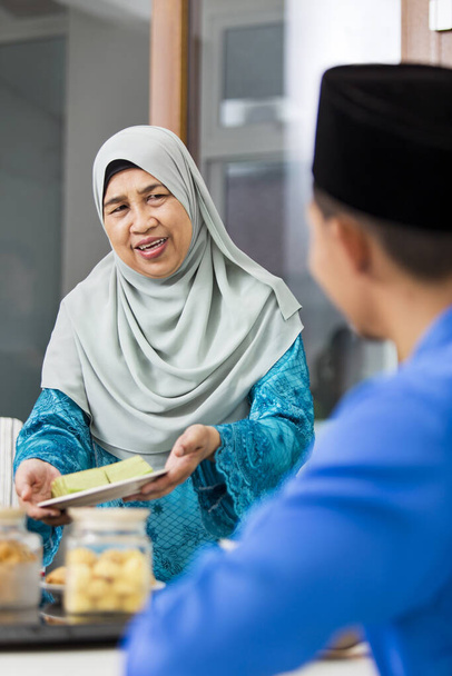Muslim woman serving food during Eid al-Fitr - Foto, Imagen