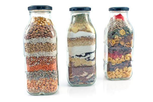 Botellas de vidrio decorativas con semillas aisladas en blanco
 - Foto, imagen