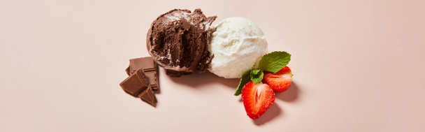 vrchní pohled na čerstvé chutné bílé a čokoládové zmrzlinové kuličky s mátou a jahodami na růžovém pozadí, panoramatický záběr - Fotografie, Obrázek