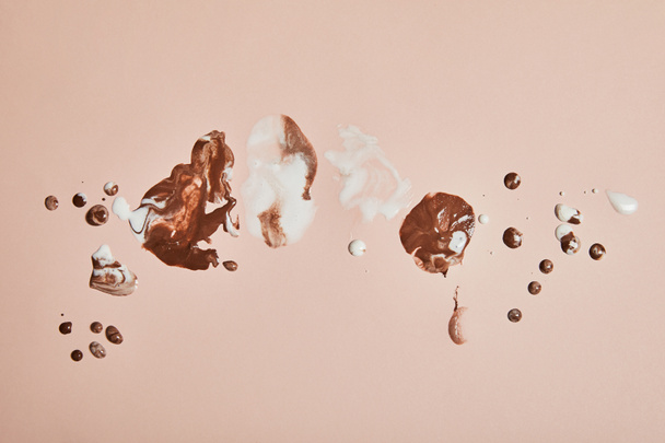 top view of melted brown and white ice cream on pink background - Foto, Imagem