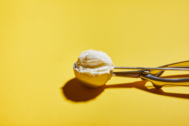 fresh tasty ice cream ball in scoop on yellow background - Fotoğraf, Görsel