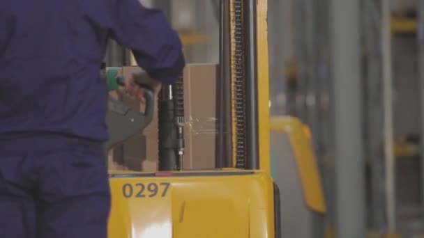 Warehouse worker with electric hydraulic forklift. Worked in a modern warehouse - Video