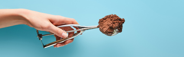 cropped view of woman holding scoop with chocolate ice cream on blue background, panoramic shot - Photo, Image