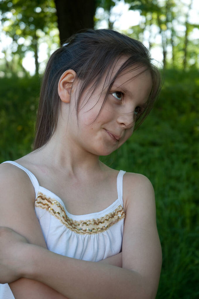 girl child with a displeased face arms crossed in the park - Photo, image