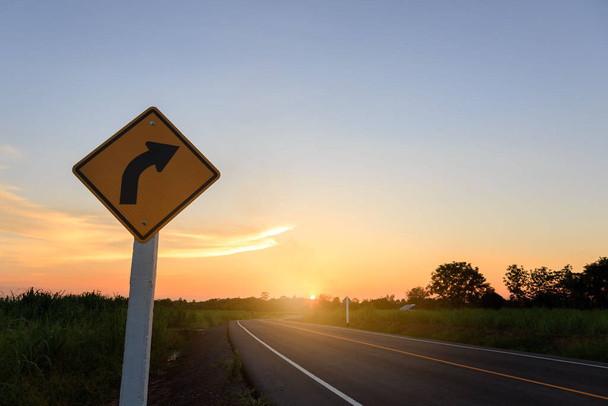 Biegen Sie rechts ab. Fahrtrichtungsanzeige- rechts Abbiegewarnung auf Sonnenuntergangshintergrund mit Leerzeichen für Text - Foto, Bild