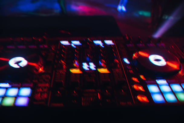 Mezclador de DJ en un club nocturno con un fondo de luces brillantes de botones
 - Foto, Imagen