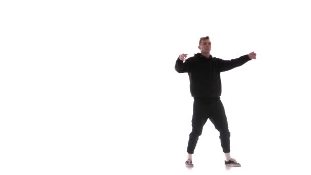 junger gutaussehender Mann im schwarzen Trainingsanzug tanzt energisch Hip Hop, Freestyle, Streetdance, vollführt komplexe Bewegungen, isoliert - Filmmaterial, Video