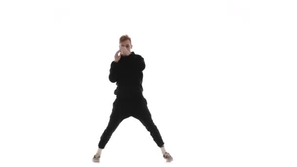 junger gutaussehender Mann im schwarzen Trainingsanzug tanzt energisch Hip Hop, Freestyle, Streetdance, vollführt komplexe Bewegungen, isoliert - Filmmaterial, Video