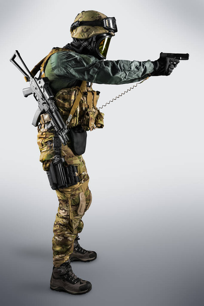 Żołnierz trzymający karabin szturmowy. Mundur odpowiada specjalnym służbom Federacji Rosyjskiej. Postrzelony w studio. Odizolowana ścieżką wycinania na szarym tle - Zdjęcie, obraz