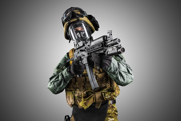 Soldado sosteniendo rifle de asalto. Uniforme se ajusta a los servicios especiales de la Federación Rusa. Grabado en el estudio. Aislado con la ruta de recorte sobre fondo gris
 - Foto, Imagen