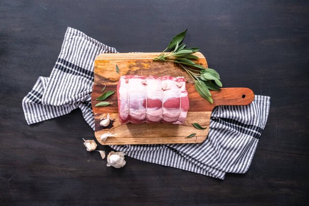 Flat lay. Uncooked boneless pork roast on the cutting board. - Foto, Imagem