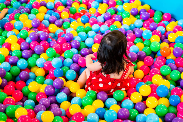 Τα παιδιά παίζουν σε χρωματιστές πλαστικές μπάλες - Φωτογραφία, εικόνα