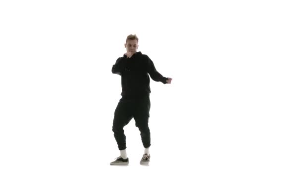 young handsome guy in black tracksuit vigorously dancing hip hop, freestyle, street dance, performs complex movements, isolated, slow motion - Footage, Video
