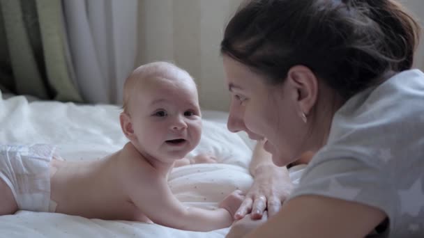 Mother And Her Newborn Baby Lie On Their Stomach In A Bed Opposite Each Other - Filmagem, Vídeo