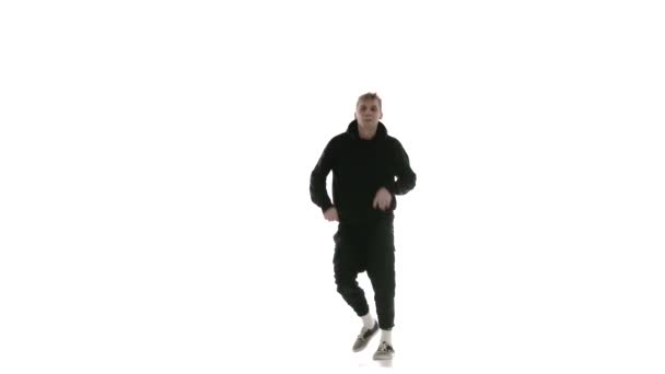 junger gutaussehender Typ in schwarzem Trainingsanzug, der energisch Hip Hop, Freestyle, Streetdance tanzt, komplexe Bewegungen ausführt, isoliert, Zeitlupe - Filmmaterial, Video