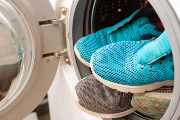 Paar sneakers in de wasmachine, close-up - Foto, afbeelding