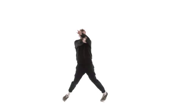 mladý pohledný chlap v černé teplákové soupravě energicky tančí hip hop, freestyle, street dance, provádí složité pohyby, izolované, zpomalený film - Záběry, video