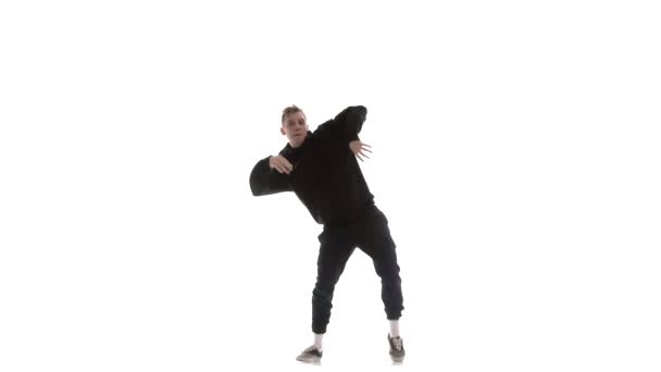ブラックトラックスーツの若いハンサムな男が精力的にヒップホップ、フリースタイル、ストリートダンスを踊り、複雑な動き、孤立した、遅い動きを実行します - 映像、動画