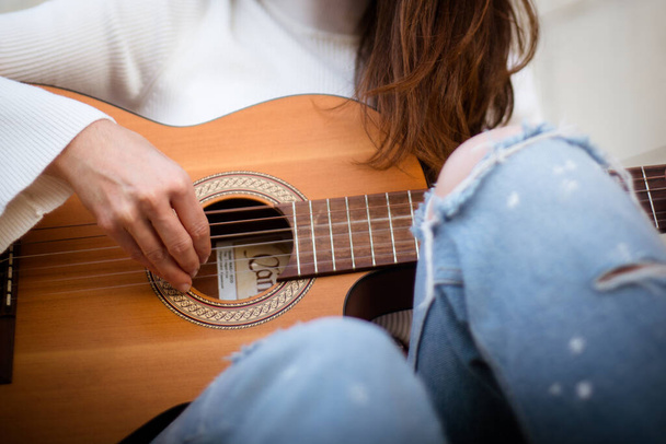 Detalhe de uma cantora tocando guitarra
 - Foto, Imagem