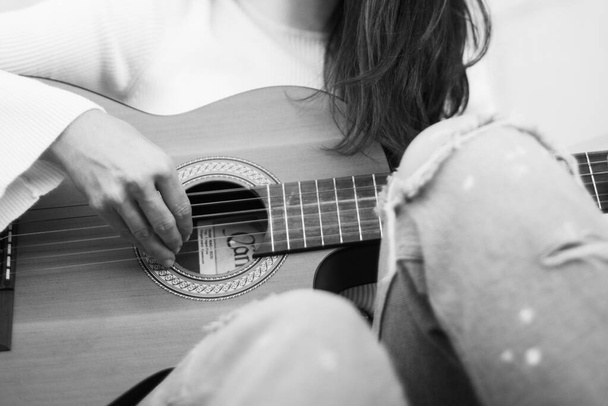 Detalle de una cantante tocando la guitarra
 - Foto, Imagen