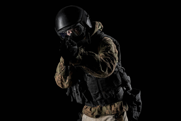 Un soldado sosteniendo un rifle de asalto. Uniforme se ajusta a los servicios especiales FSB de la Federación Rusa. Grabado en el estudio. Aislado con ruta de recorte sobre fondo negro
 - Foto, Imagen