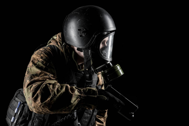 One soldier holding assault rifle. Uniform conforms to special services FSB of the Russian Federation. Shot in studio. Isolated with clipping path on black background - Zdjęcie, obraz