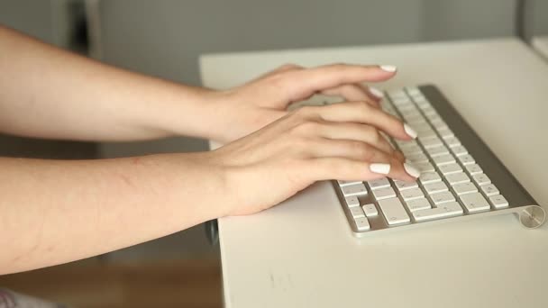 Womans hand typing on white keyboard. Woman working at the computer. Office worker - Materiał filmowy, wideo