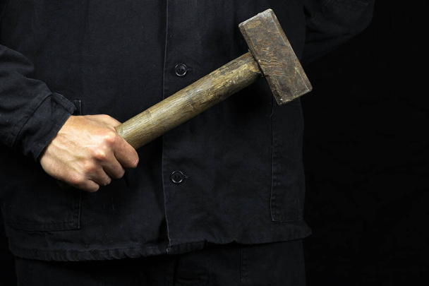 marteau, marteau dans la main d'un travailleur sur un fond noir
 - Photo, image