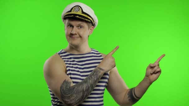 Mladý námořník ukazuje na něco rukama. Námořník v námořnické vestě - Záběry, video