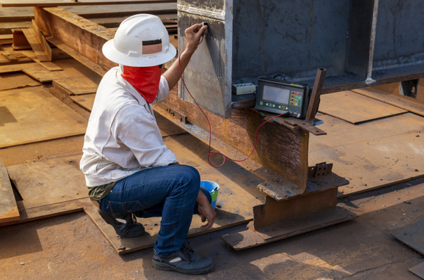 Die Inspektoren prüfen Defekte an geschweißten Stahlverbindungen mit Ultraschallprüfung (UT) der zerstörungsfreien Prüfung (NDT) im Industriewerk. - Foto, Bild