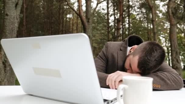 Young male businessman is sleeping and waking up at the workplace. - Filmmaterial, Video