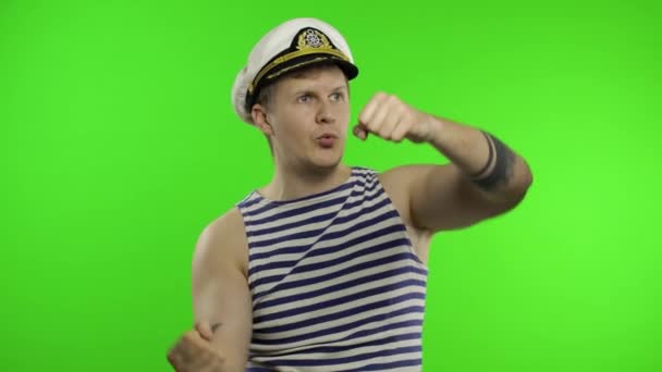 Geminin hayali tekerleği olan genç bir denizci. Denizci yeleği giyen denizci. - Video, Çekim