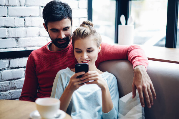 Positive generation couple in love reading received email connected to 4g wireless on mobile gadget, Caucasian husband and wife chatting and browsing websites via app enjoying blogging lifestyle - Fotoğraf, Görsel