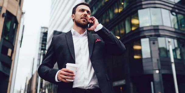 Debajo de la vista de los expertos en análisis de negocios llamando a un socio para comunicarse durante la pausa del café en el distrito financiero utilizando la conexión internacional de roaming 4g, el concepto de conversación móvil del operador. - Foto, imagen