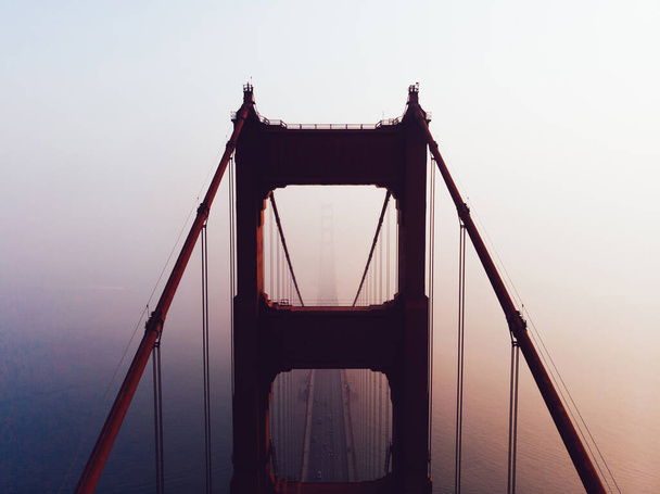 Aerial view silhouette of Golden Gate tower bridge Sight in San Francisco during foggy sunset time, scenery suspension construction, metropolitan transportation infrastructure. California landmark  - Zdjęcie, obraz
