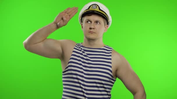Genç denizci elleriyle selam veriyor, yukarı bakıyor. Denizci yeleği giyen denizci. - Video, Çekim
