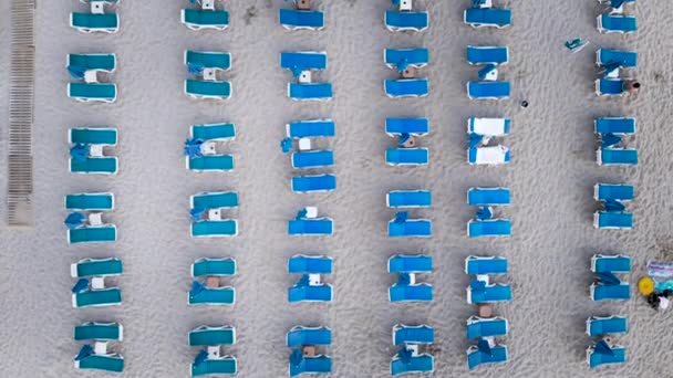 Vista aérea Sombrillas de playa vista superior perspectiva aérea. Azul, vacaciones de una playa con muchedumbre disfrutando del mar
 - Metraje, vídeo