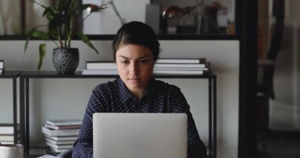 Serious indian businesswoman using laptop thinking looking away in office - Video, Çekim