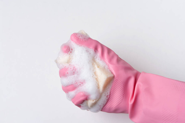 Hand squeezes eco cleaning sponge, isolated on white background. Soap foam. - Photo, Image