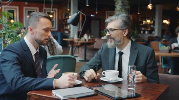 Joyful men colleagues talking and laughing relaxing in cafe during coffee break - Metraje, vídeo