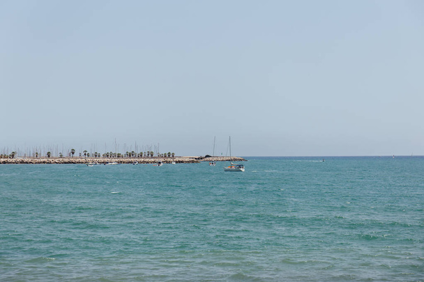Yates en el mar cerca del muelle con cielo azul al fondo en Cataluña, España
  - Foto, imagen